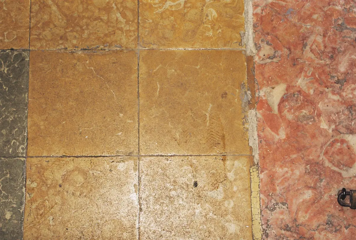 Worn yellow limestone and pink marble floor tiles