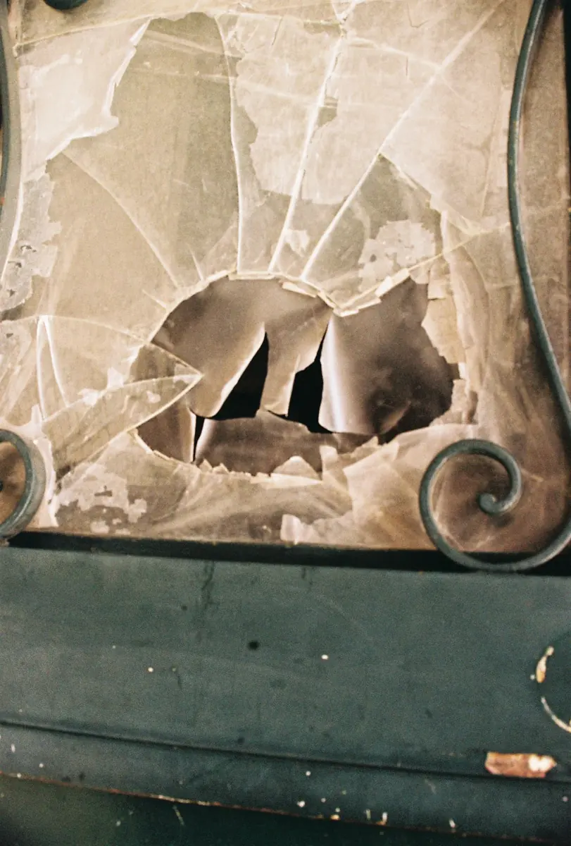 Broken glass in a green-framed window