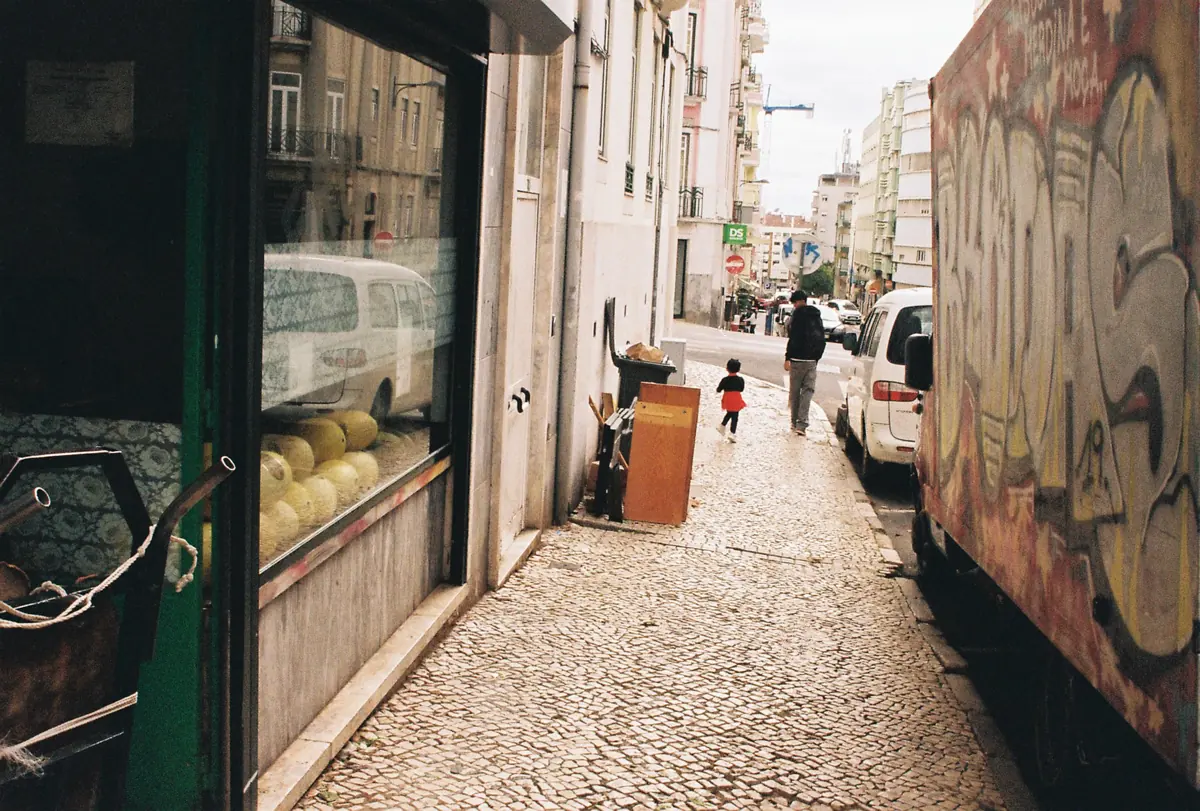 A cobbled street with graffiti on the wall