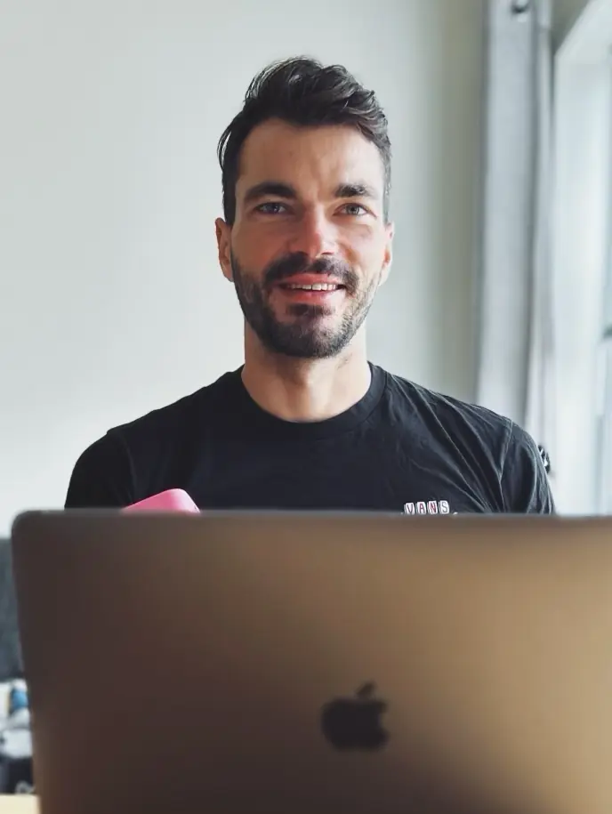 Martin smiling behind a laptop