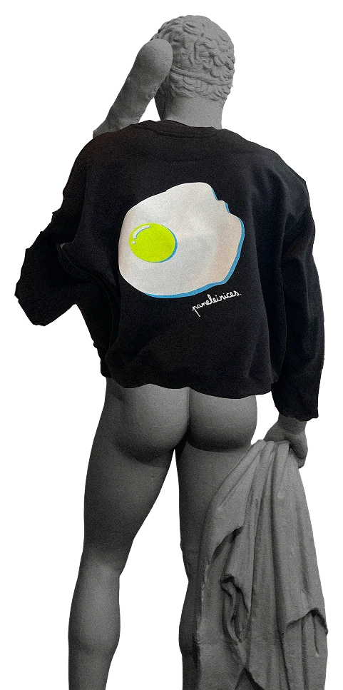 A 3D statue seen from behind, wearing a black sweater with a fried egg graphic