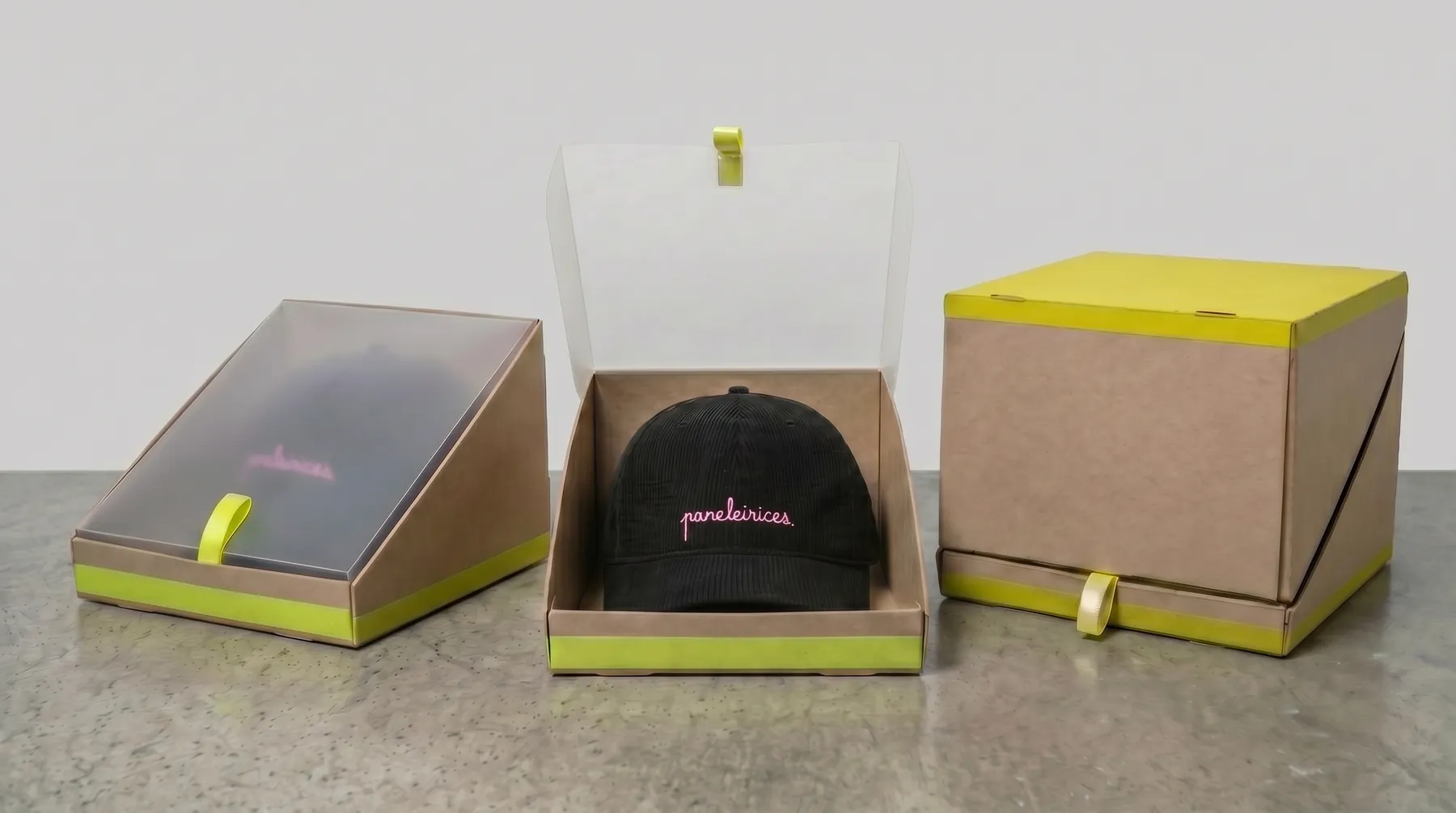 The display box from the side: a kraft wedge with a neon base and the cap drawn in neon line