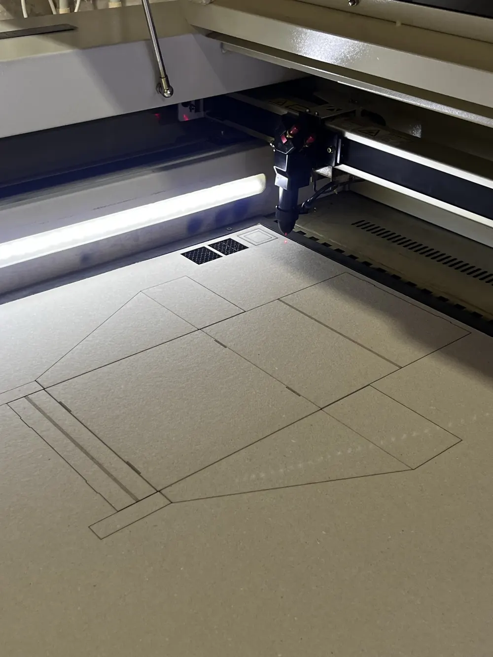 The laser cutter drawing the box onto a sheet of board