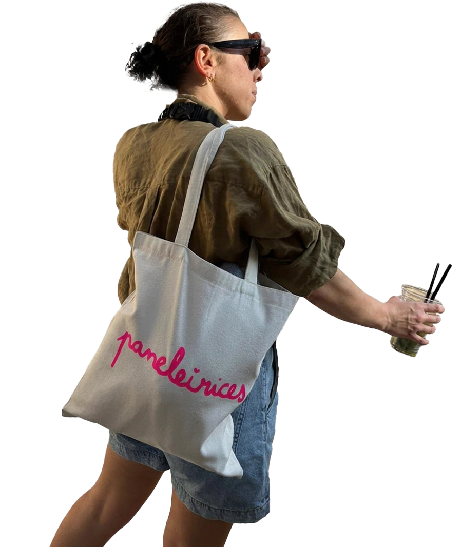 Sofia with a Paneleirices tote bag over her shoulder, seen from the side. Hover to see her from behind.