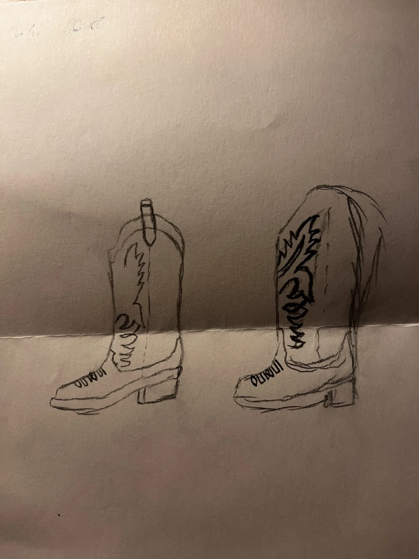 Pencil sketches of two cowboy boots on a folded sheet of paper