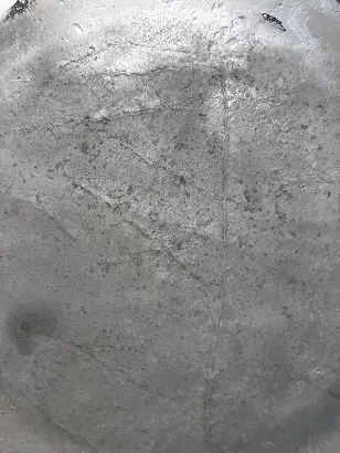 Close-up of ice scratched with knives, a pale gray surface with fine marks