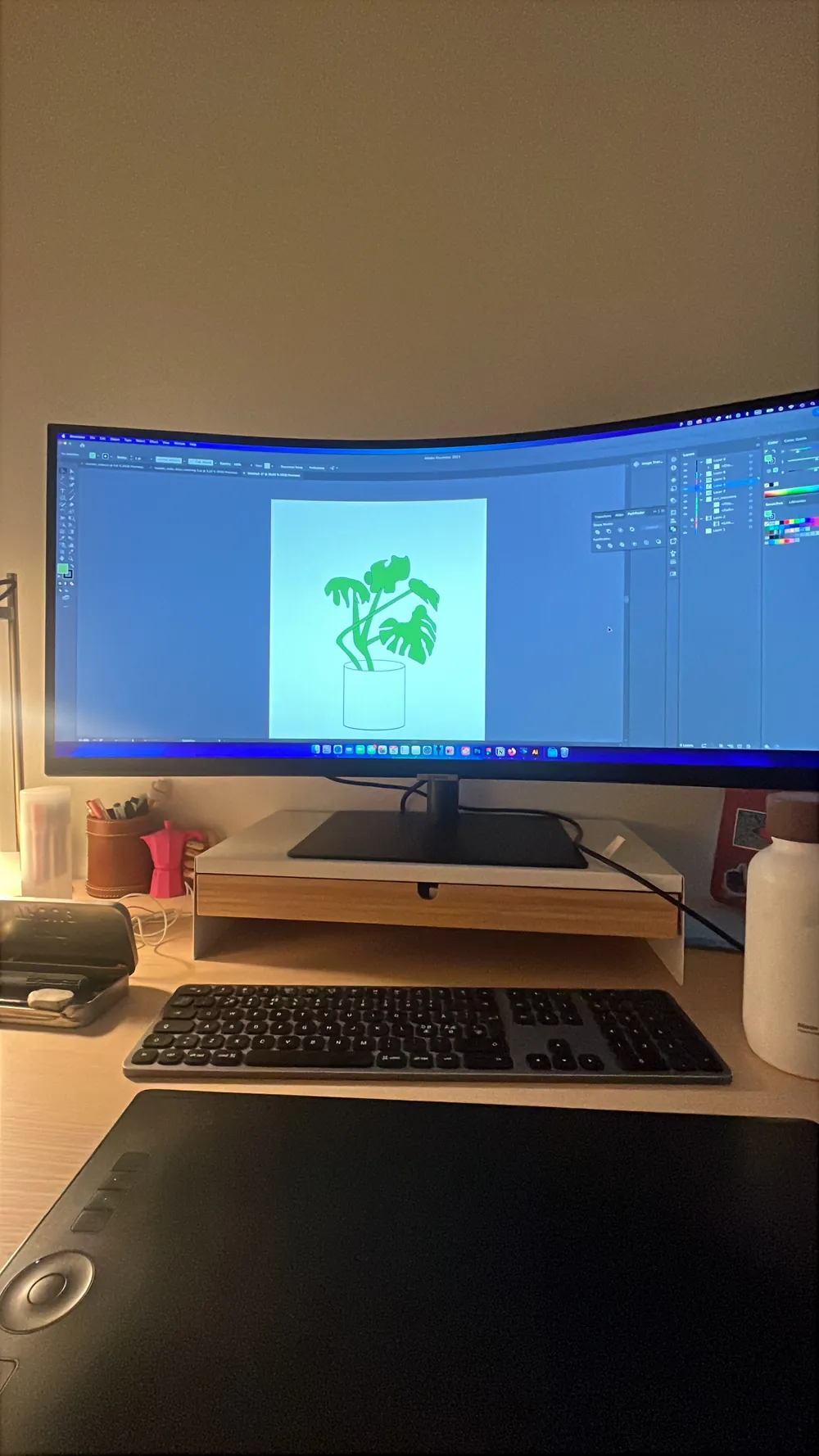 The desk setup: a curved monitor showing the illustration artboard, a drawing tablet and a keyboard