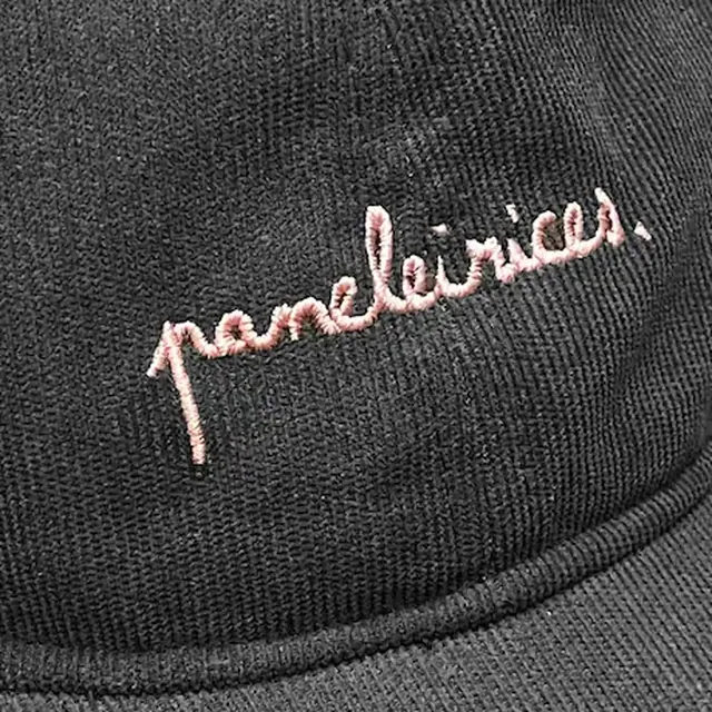 Paneleirices: close-up of the pink embroidered logo on a black cap