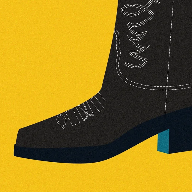 A black cowboy boot on mustard yellow